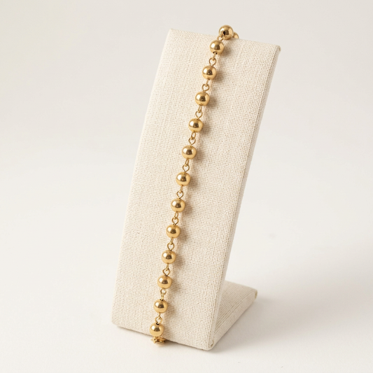 Bracelet Grains d'Or sur un présentoir en lin ivoire