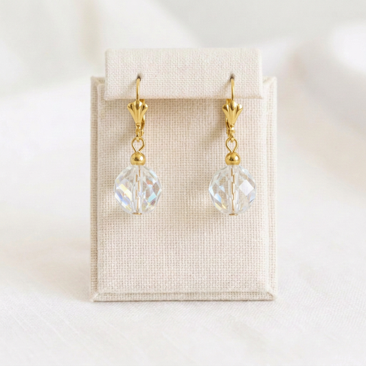 Paire de boucles d’oreilles en verre facetté sur présentoir en lin ivoire