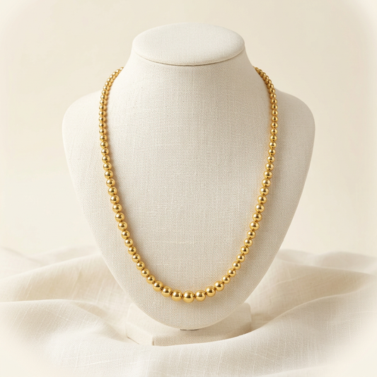 Collier Boules Dégradées en plaqué or sur buste en lin ivoire