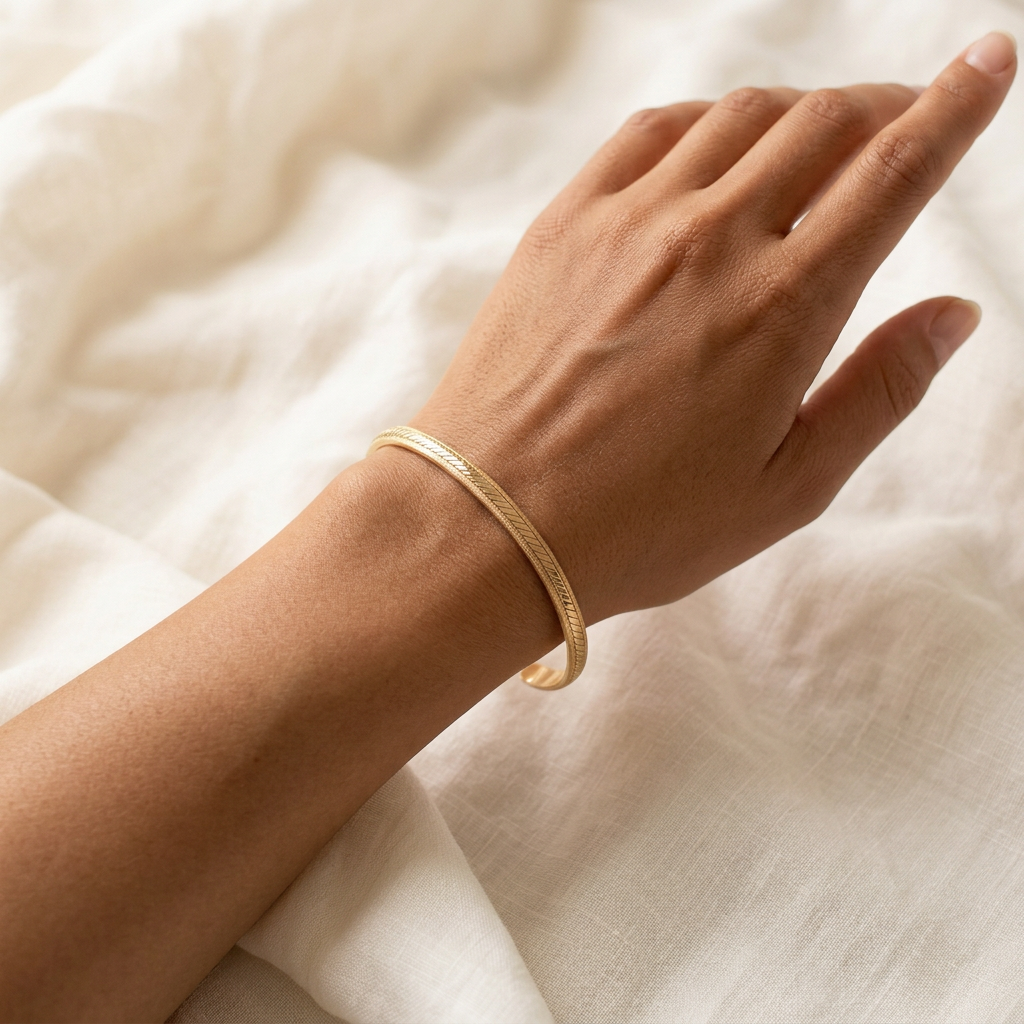 Petit bracelet jonc doré porté par une femme métisse